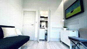 Una camera moderna e funzionale con un letto, una scrivania e angolo cottura.