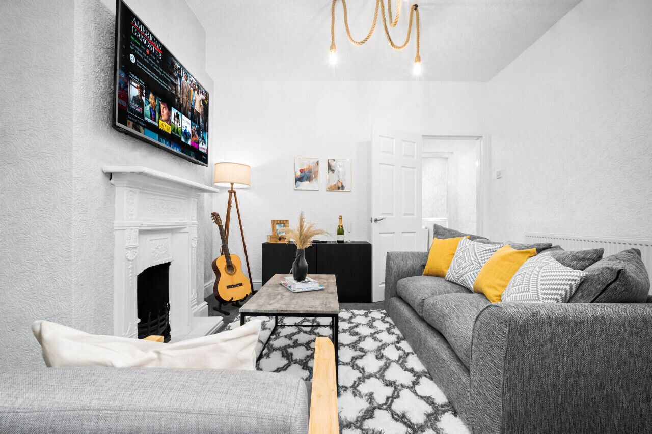 A living room with a fireplace, a television mounted on the wall, a sofa, and a coffee table.