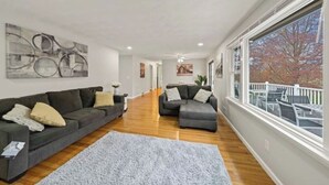A spacious living room with two sofas and a large window. - Fresh, fabulous home on 4 acres! (Penfield)
