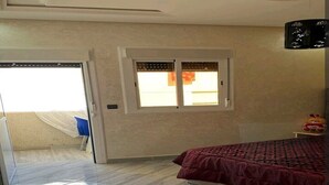 Una camera da letto con un letto, una finestra e un accesso a un balcone.