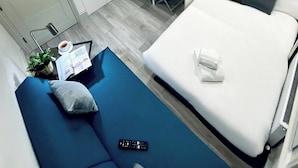 A modern hotel room with a bed, a desk, a TV, and a seating area. - Apt. 05 - Stylish Studio Steps from Sea, Bars & Promenade (Brighton and Hove)
