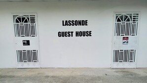 A building labeled "LASSONDE GUEST HOUSE" with two doors, one marked "Reception" and the other with a "NO PARKING" sign.