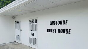 Un edificio blanco con dos puertas y un cartel que dice 'LASSONDE GUEST HOUSE'.
