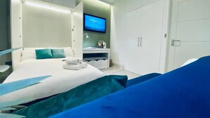 Een moderne hotelkamer met een groot bed, een televisie en een kledingkast.