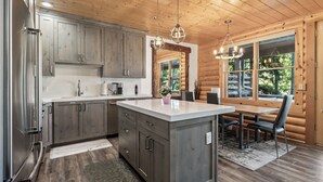 Une cuisine moderne avec des meubles en bois, des appareils en acier inoxydable et un îlot central.