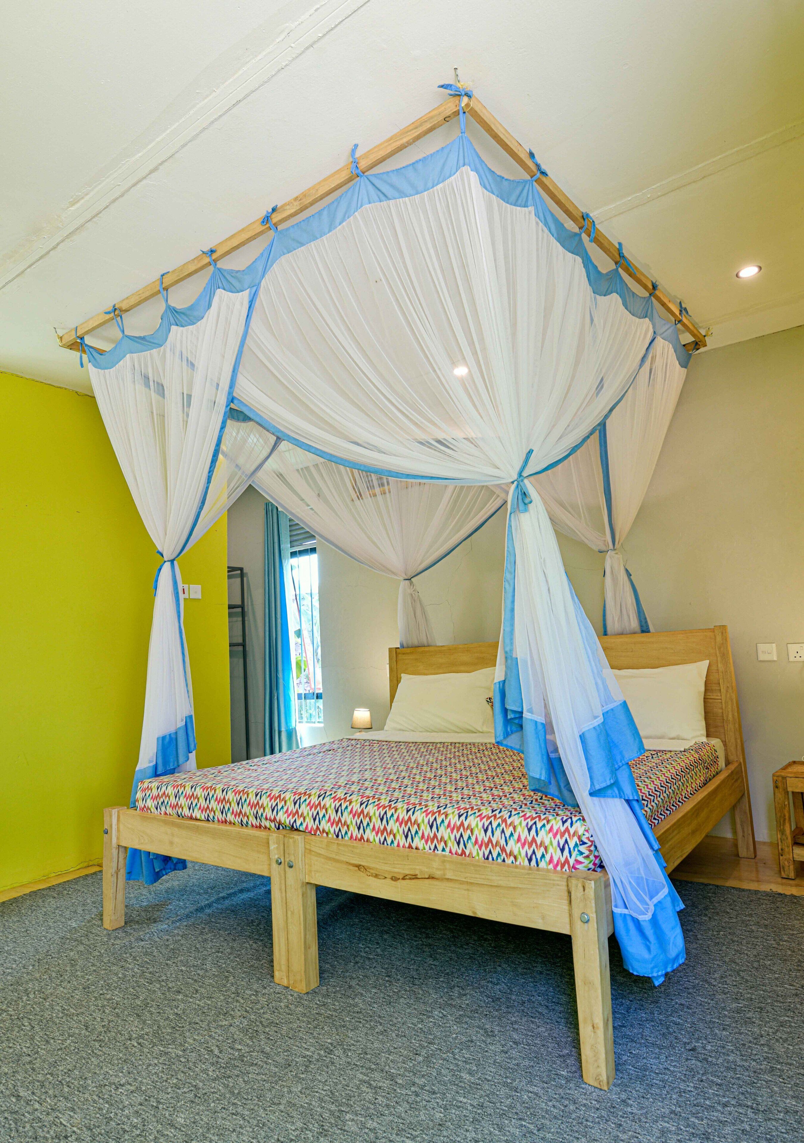 A single bed with a canopy, a bedside table, and a nightstand.