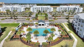 Un complexe résidentiel comprenant plusieurs immeubles d’appartements, une piscine centrale et des espaces paysagers.