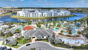 A resort with a central pool, a water park, and multiple buildings with balconies. - New Discount Disney Lazy River TikiBar Balcony (Kissimmee)