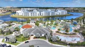 A resort with a central pool, a water park, and multiple buildings with balconies.