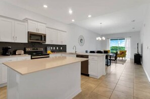 Enjoy cooking in this well-equipped kitchen with a large island, microwave, stove, and dishwasher.