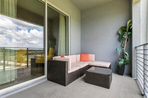 Relax on the spacious balcony with a sofa, coffee table, and potted plant.