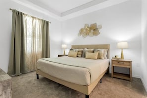 Une chambre à coucher avec un grand lit, deux tables de chevet avec des lampes, un élément décoratif mural et une fenêtre avec des rideaux.