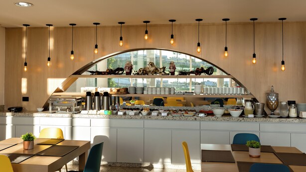 A modern kitchen with a breakfast bar, wooden cabinets, and pendant lighting. - GoldMen Express Cianorte (Cianorte)