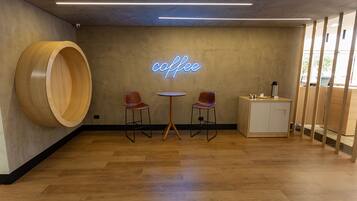 En moderne café med træmøbler, et neonskilt og et træskab.