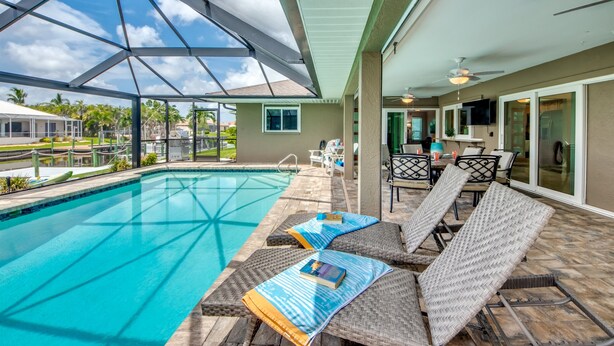 Ein Poolbereich mit Liegestühlen und einer überdachten Terrasse.
