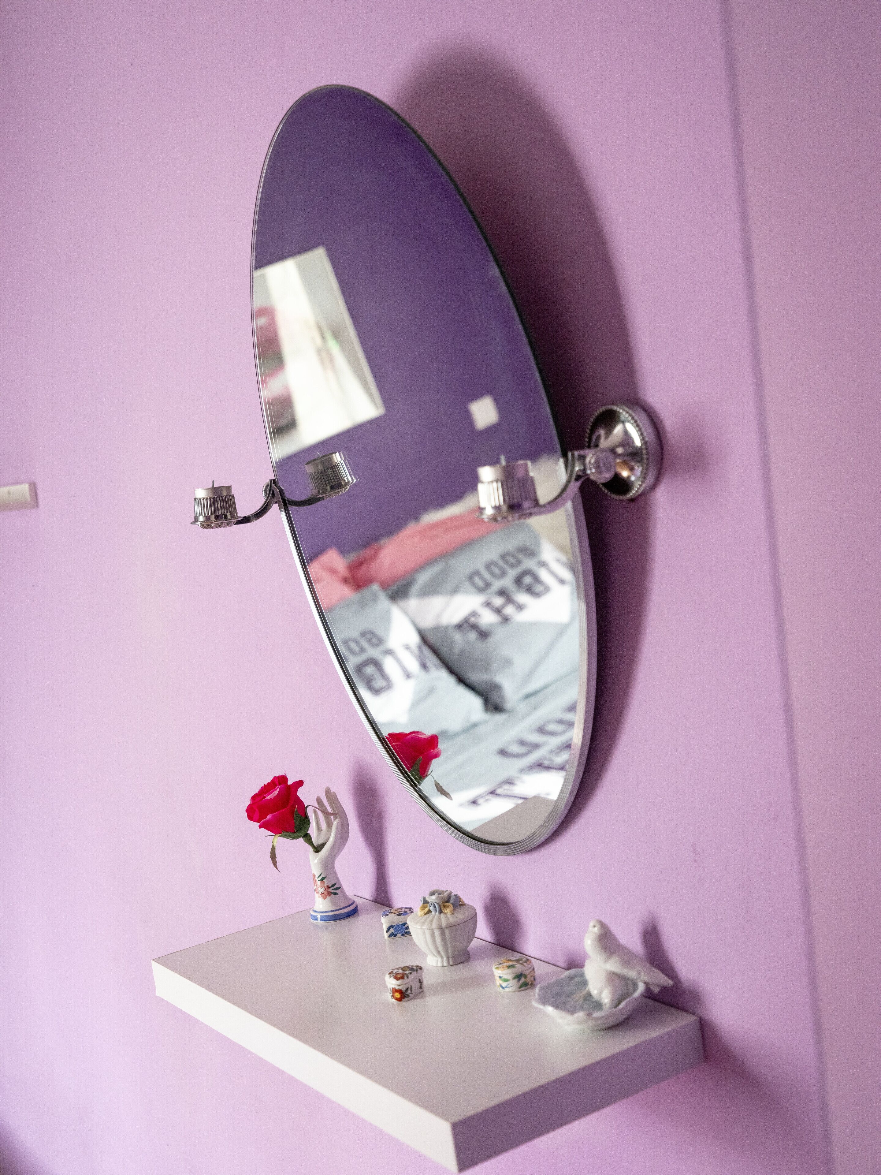 Specchio con cornice viola fissato a una parete.
