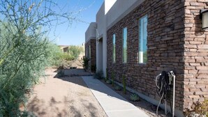 A modern building with a stone facade and blue window frames. - Home with Four Peaks  and  Mountain views just outside Tonto National Forest 
 (Rio Verde)