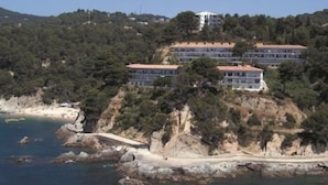 Ein Küstenhotel mit mehreren Gebäuden, einer felsigen Uferlinie und freiem Blick auf das Meer.