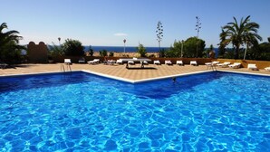 A swimming pool with clear blue water, surrounded by lounge chairs and a view of the ocean. - Comfortable apartments with swimming pool facing the sea. Ref. Cala Llevadó-46 (Tossa del mar)
