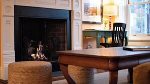 A cozy living room with a fireplace, a dining table, and a comfortable seating area.
