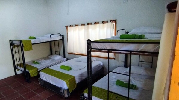 Un dormitorio con literas, una cortina y suelo de baldosas.