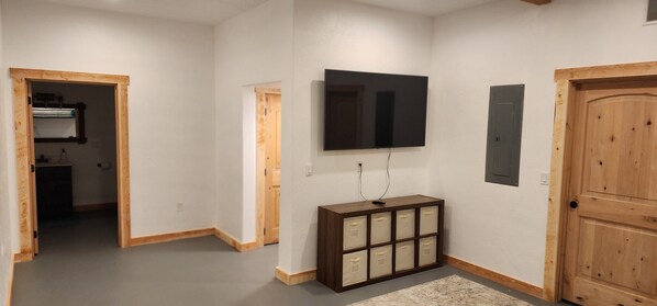 A hallway with a wooden door, a mounted television, and a storage unit. - NEW 7500 sf, 5BR/7BA/Basement within walking distance to the Clark Fork river. (Thompson Falls)