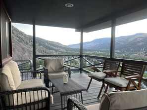 A covered outdoor seating area with wicker furniture and a view of a mountainous landscape. - Tower House - Views in all directions! Newly Remodeled (Lake City)