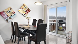 Ein Essbereich mit Tisch und Stühlen, einer Chandelier und Kunstwerken an der Wand.