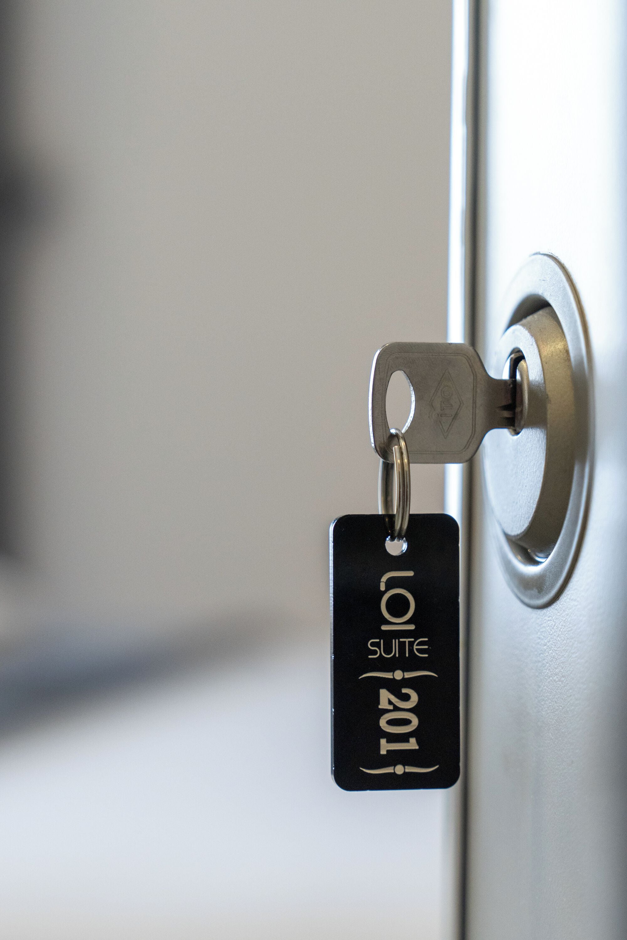 Une clé munie d’une étiquette fixée à une serrure de porte.
