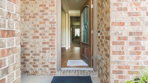 A brick exterior with a wooden door and a doormat. - Feel At Home in Richmond (Richmond)