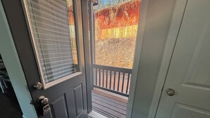 A dark grey door with a window, a white door, and a wooden deck with a railing. - Golf View located in Valhalla Resort! Minutes to Oktoberfest! (Helen)