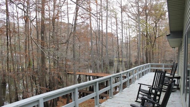 A wooden deck with railings overlooking a forested area. - Waterfront 5 Bedroom (Karnack)