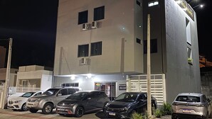 A modern building with a parking lot, several parked cars, and a sign indicating a business establishment. - Bueno's Hotel Francisco Beltrão (Francisco Beltrao)