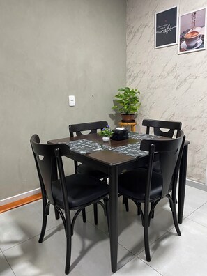 A dining area with a marble wall, a potted plant, and a framed picture. - Bueno's Hotel Francisco Beltrão (Francisco Beltrao)