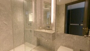 A modern bathroom with a glass shower enclosure, a marble vanity, and a large mirror. - Chelsea Harbour 2-bed Apartment in London (London)