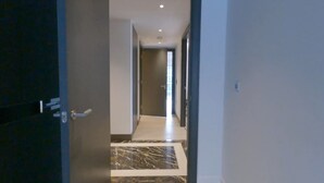 A hallway with a marble floor leading to a door. - Chelsea Harbour 2-bed Apartment in London (London)