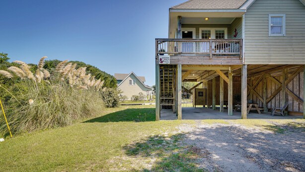 A two-story house with a covered porch and a deck. - Near Ocean: Buxton Townhome w/ Patio! (Buxton)