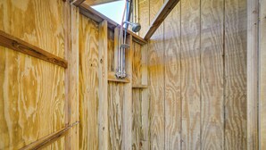 A wooden interior with a skylight, wooden beams, and a shower area. - Near Ocean: Buxton Townhome w/ Patio! (Buxton)