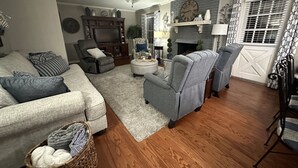 A living room with a grey sofa, a grey armchair, a wooden coffee table, and a ceiling fan.