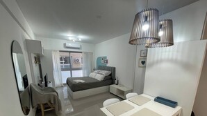 A modern bedroom with a bed, bedside table, and a desk with chairs. - Modern Studio in San Telmo (Buenos Aires)