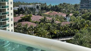Un hôtel de grande hauteur offrant une vue sur l’océan et les palmiers.