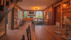 A wooden interior with a dining area, a staircase, and a large window. -  7 bedrooms, 4 bathrooms, located in Beach Lake, PA. Sleeps 16, Max capacity  21 (Beach Lake)