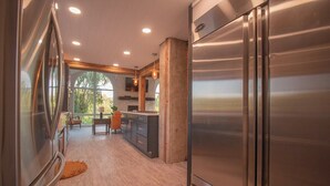 A modern kitchen with stainless steel appliances, a wooden floor, and a view of the outdoors through large windows. -  7 bedrooms, 4 bathrooms, located in Beach Lake, PA. Sleeps 16, Max capacity  21 (Beach Lake)