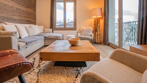 Uma sala de estar aconchegante com sofá, poltrona e mesa de centro.