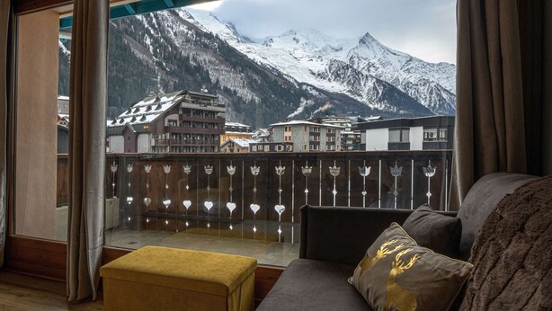 Un balcon offrant une vue sur des montagnes et des bâtiments enneigés.