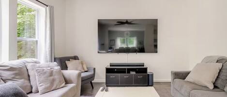 A modern living room with two sofas, a flat-screen TV, and a coffee table.