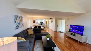 A modern living room with a sectional sofa, a coffee table, and a flat-screen TV. - Grand Family Deluxe 3BD Condo Near Disney Universal 22 (Kissimmee)