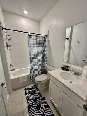 A bathroom with a bathtub, toilet, and sink. - Grand Family Deluxe 4BD House Near Disney Parks (Davenport)