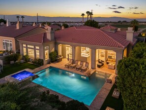 Une maison de luxe dotée d’une piscine, d’un espace extérieur aménagé et offrant une vue sur les montagnes.