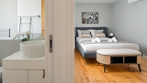 Un dormitorio moderno con cama, mesita de noche y un ventanal grande.